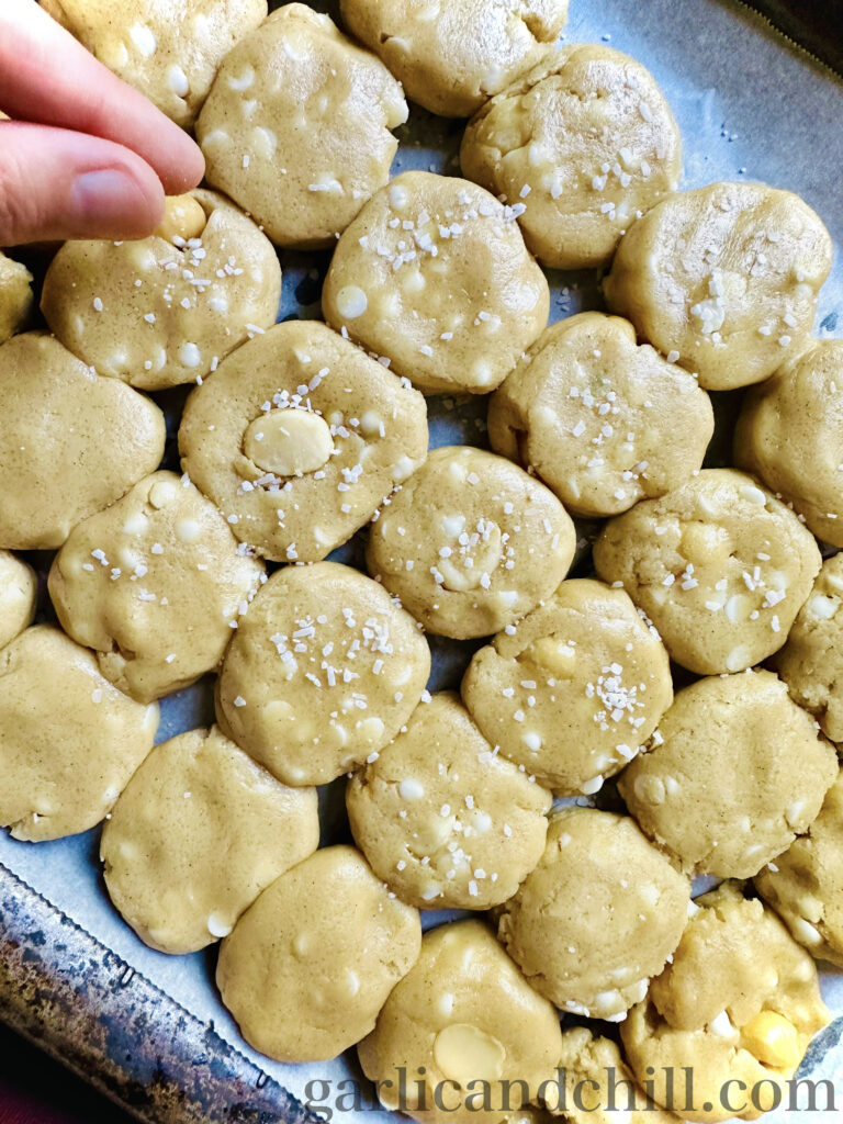 Adding salt on top the Vegan Salted White Chocolate Macadamia Cookie doughs