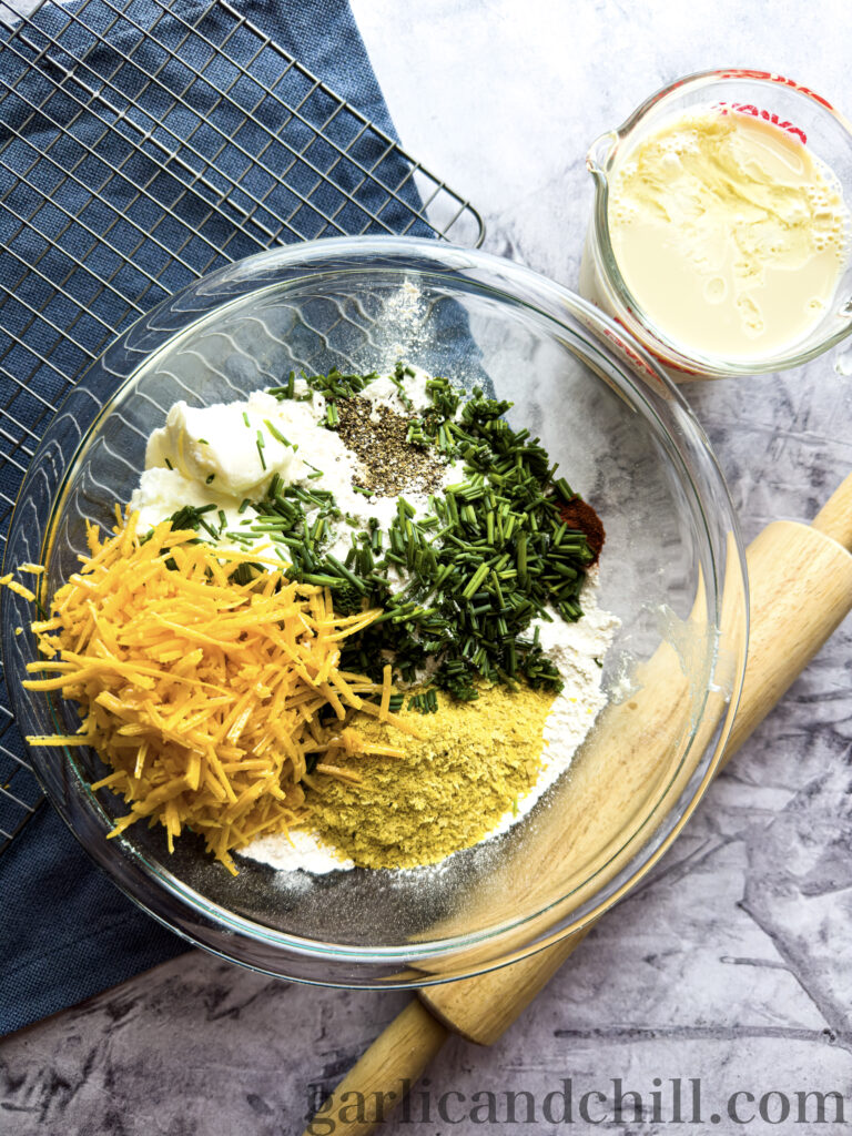 Bowl full of cheddar chive biscuit ingredients