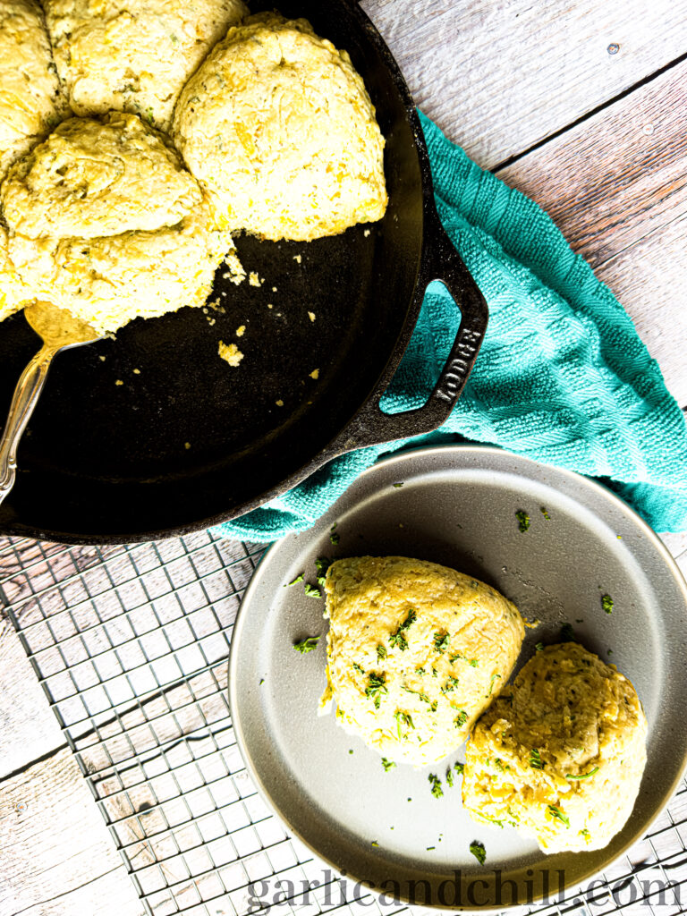 Vegan Cheddar Chive Buttermilk Biscuits in an iron skillet and on a plate